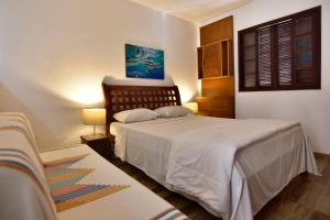 1 dormitorio con 2 camas y ventana en Estalagem 11 Suites, en Arraial do Cabo