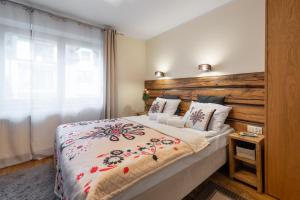 een slaapkamer met een groot bed met een houten hoofdeinde bij Orkana Home in Zakopane