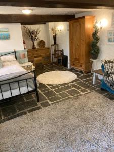 a bedroom with a bed and a rug on the floor at Mill Retreat at Bissick Old Mill in Truro