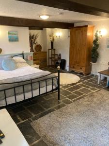 a bedroom with a large bed and a room with a table at Mill Retreat at Bissick Old Mill in Truro