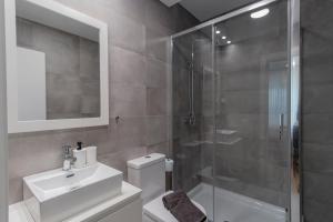 ein Bad mit einer Dusche, einem Waschbecken und einem WC in der Unterkunft Cozy Studio w/ Patio by LovelyStay in Porto