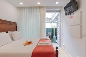 ein Schlafzimmer mit einem Bett und einem Tablett darauf in der Unterkunft Cozy Studio w/ Patio by LovelyStay in Porto
