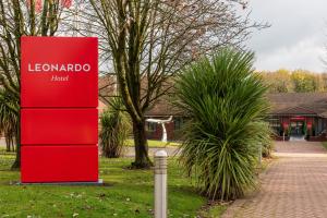 ein rotes Schild mit der Aufschrift leomoholoco in einem Park in der Unterkunft Leonardo Hotel East Midlands Airport in Castle Donington