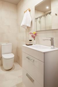 a white bathroom with a toilet and a sink at Tanau by FeelFree Rentals in Naut Aran