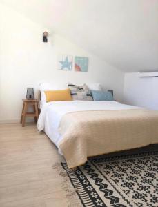 een slaapkamer met een groot bed en een tapijt bij Sinos da Sé in Setúbal
