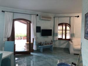 un soggiorno con divano e TV di Appartamento in villa Porto Istana a Olbia