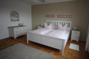 Ferienwohnung Bothe في Zandt: غرفة نوم مع سرير مع وسائد وردية وبيضاء