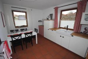 a kitchen with a sink and a table with chairs at Ferienwohnung Bothe in Zandt