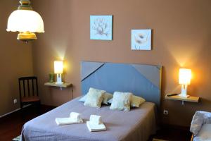 a bedroom with a bed with two towels on it at Bella Italia Populo Guest House in Ponta Delgada +98 photos
