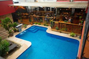 a large swimming pool in front of a restaurant at La Fortuna Downtown Hotel Boutique in Fortuna
