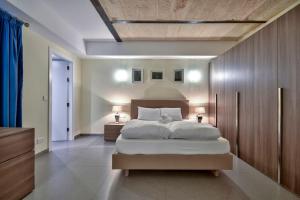 um quarto com uma cama grande e duas mesas de cabeceira em VALLETTASTAY - ORANGERIE TWO BEDROOM APARTMENT 201 em Valletta