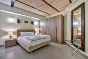 um quarto com uma cama grande e um espelho em Orangerie 201 by Vallettastay em Valeta mais 18 fotografias