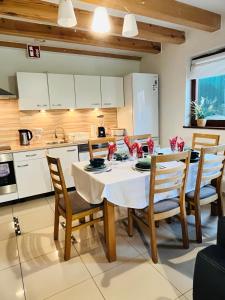 kuchnia ze stołem i krzesłami w pokoju w obiekcie kormoran-sarbinowo w Sarbinowie