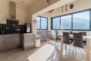 a kitchen with a table and chairs and windows at Villa Clearvue 