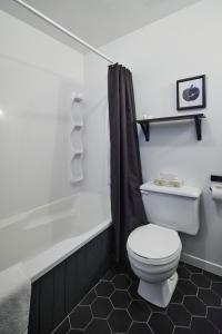 a bathroom with a toilet and a bath tub at Beatnik Hotel in Bromont