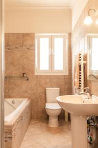 a bathroom with a toilet and a sink and a tub at Villa Clearvue 