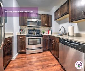 a kitchen with stainless steel appliances and wooden cabinets at Renu At Back Bay in Boston