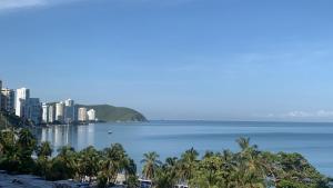 vista su una città e sull'oceano con palme di Luna Azul Rodadero apartaestudios a Santa Marta