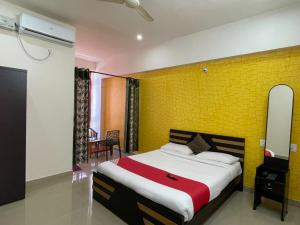 a bedroom with a bed and a yellow wall at Green Valley Residency in Gundlupet