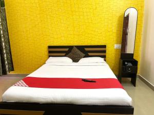 a bedroom with a large bed with a yellow wall at Green Valley Residency in Gundlupet