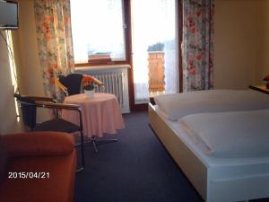 um quarto de hotel com uma cama e uma mesa e uma mesa e cadeiras em Pension Jodlbauer em Schöllnach