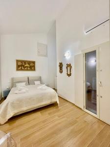 a white bedroom with a bed and a bathroom at Home Viale Trento 16 in Cagliari