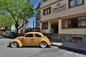 a small yellow car parked in front of a building at Pousada Stillo Gramado Centro - 300 metros da rua coberta in Gramado