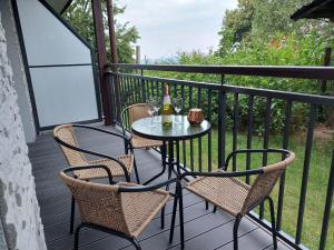 a table with two chairs and two bottles of wine on a balcony at Apartament Pod Papugami 2 Karpatia Resort in Karpacz