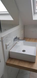 lavabo blanco en el baño con espejo en Joanna Apartment - Worms en Worms