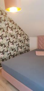 a bedroom with a blue bed with a floral wall at Joanna Apartment - Worms in Worms