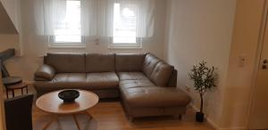 a living room with a leather couch and a table at Joanna Apartment - Worms in Worms