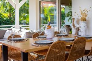 un tavolo in legno con sedie e bicchieri da vino di Tropicana Palm Penthouse Jan Thiel, Willemstad Curacao a Jan Thiel