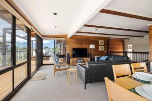 a living room with a black leather couch and a table at Kelton Beach Haven in Mollymook