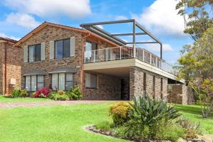 a brick house with a balcony on top of it at Kelton Beach Haven in Mollymook