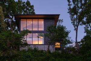 伊東市にあるPlayliving IZU - A ocean view villa with Onsenの窓に太陽が輝く家