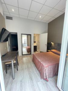 Dormitorio con cama, escritorio y TV en Hotel de La Comédie, en Montpellier