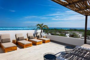 a patio with chairs and a view of the ocean at Balkon Boutique Hotel in Playa del Carmen