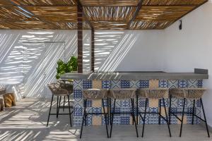 a kitchen with a bar with stools and tiles at Balkon Boutique Hotel in Playa del Carmen