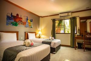 a bedroom with two beds with stuffed animals on them at Royal Vista in Patong Beach