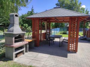 a wooden gazebo with a table and a stove at Holiday home in Balatonfenyves 18431 in Balatonfenyves