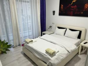 a bedroom with a white bed with two towels on it at City Park Residence in Constanţa