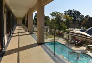 a balcony of a house with a swimming pool at Inn and Out Plus Craighall in Johannesburg