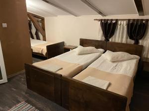 2 letti singoli in una camera da letto con specchio di Hanul La Cetate - Cazare pentru muncitori și delegați a Slimnic