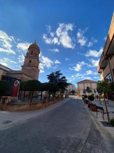 una calle adoquinada frente a un edificio con una torre del reloj en La Posada de San Miguel, en Andújar