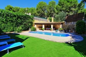 a yard with a swimming pool and lawnitures at El Ranchito in Paguera