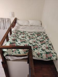 a bed with a floral comforter on it at Nikolettas Studios Traditional House in Paradeísion