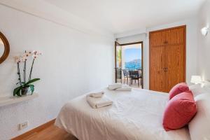 a bedroom with a large white bed with pink pillows at Anita Apartments in Port de Pollensa