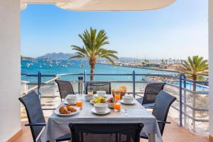 a table with food and a view of the ocean at Anita Apartments in Port de Pollensa