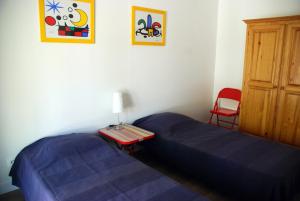 sypialnia z niebieskim łóżkiem i czerwonym krzesłem w obiekcie Le Mas de la Palmeraie - Appartement dans propriété privée au calme avec piscine et tennis w mieście Bormes-les-Mimosas