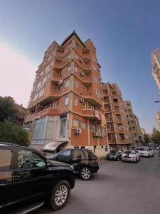 un grand bâtiment avec des voitures garées devant dans l'établissement Аппартамент Мтацминда, à Tbilissi